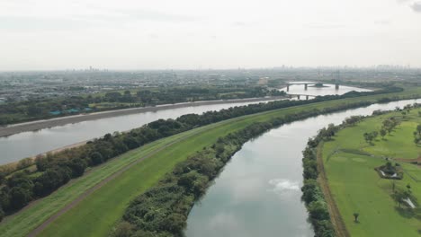 Impresionante-Paisaje-Del-Río-Arakawa-Con-Hierba-Exuberante-En-La-Berma-En-Saitama,-Japón