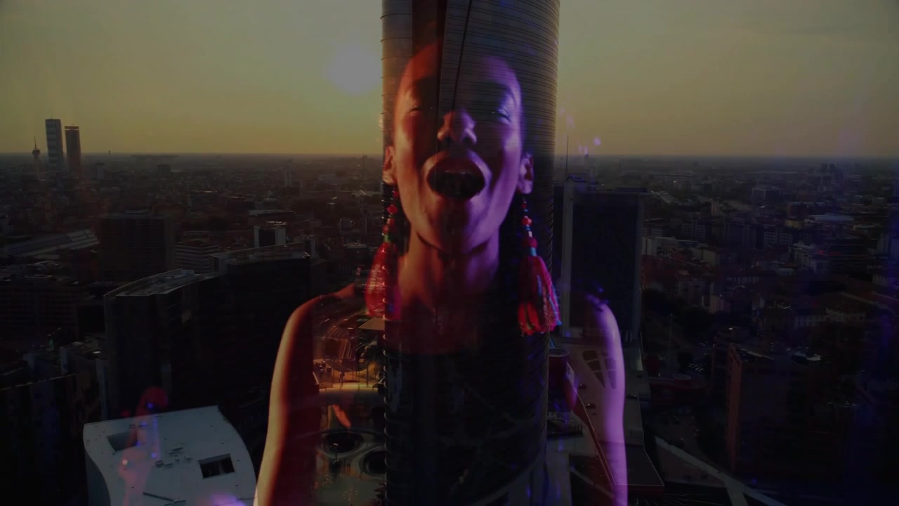 Musicista donna che inizia suonando i tasti, la telecamera che si alza, fondendosi con lo skyline, eseguendo musica sul tetto