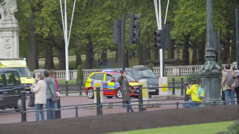 polizeiauto und krankenwagen rasen am buckingham palace vorbei