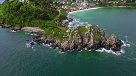pointe du chateau rocky headland and secluded beach, green peninsula surrounded by sea with waves, perros-guirec, brittany, france. aerial drôe top-down forward