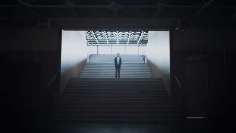 Lonely schoolboy posing standing empty school campus staircase after classes.