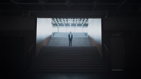 lonely schoolboy posing standing empty school campus staircase after classes.