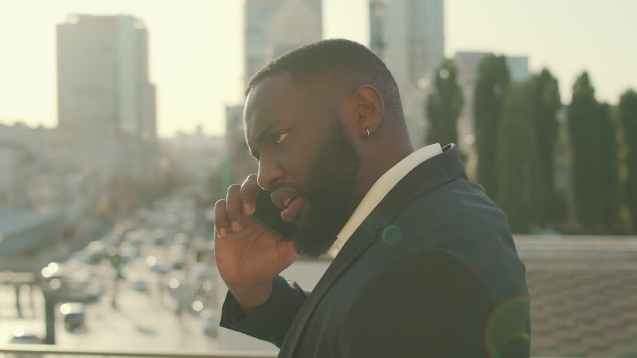 Uomo d'affari africano che fa una telefonata in città. Dirigente che parla allo smartphone.