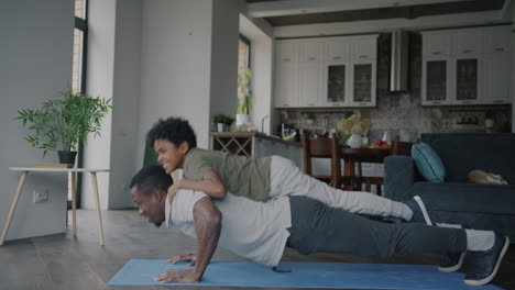 father and son doing push-ups together at home