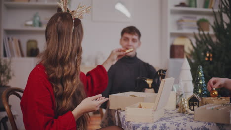 woman giving christmas ornament to male friend