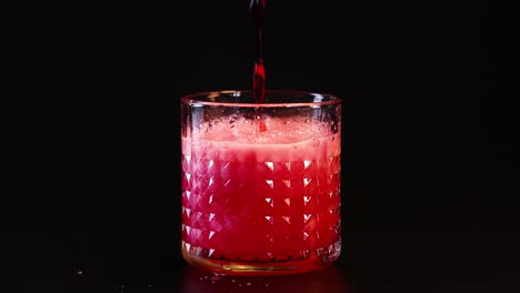 red fizzy drink poured into a glass