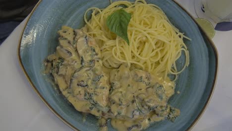 pechuga de pollo funghi en salsa alfredo con champiñones acompañado de spaghetti al burro