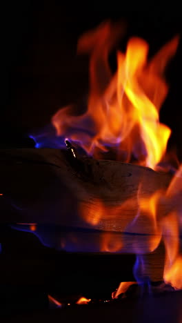 roaring flames in modern fireplace. glowing fire in a huge stone fireplace. vertical video