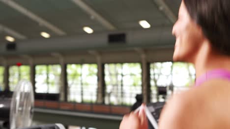 Fit-woman-running-on-treadmill-with-trainer-timing-her