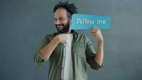 man holding a sign that says 'follow me'