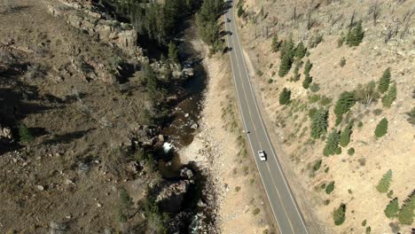 Plataforma-Rodante-Aérea-Sobre-Carretera-En-Cañón-Con-Autos-Al-Lado-Del-Río-En-Colorado-1