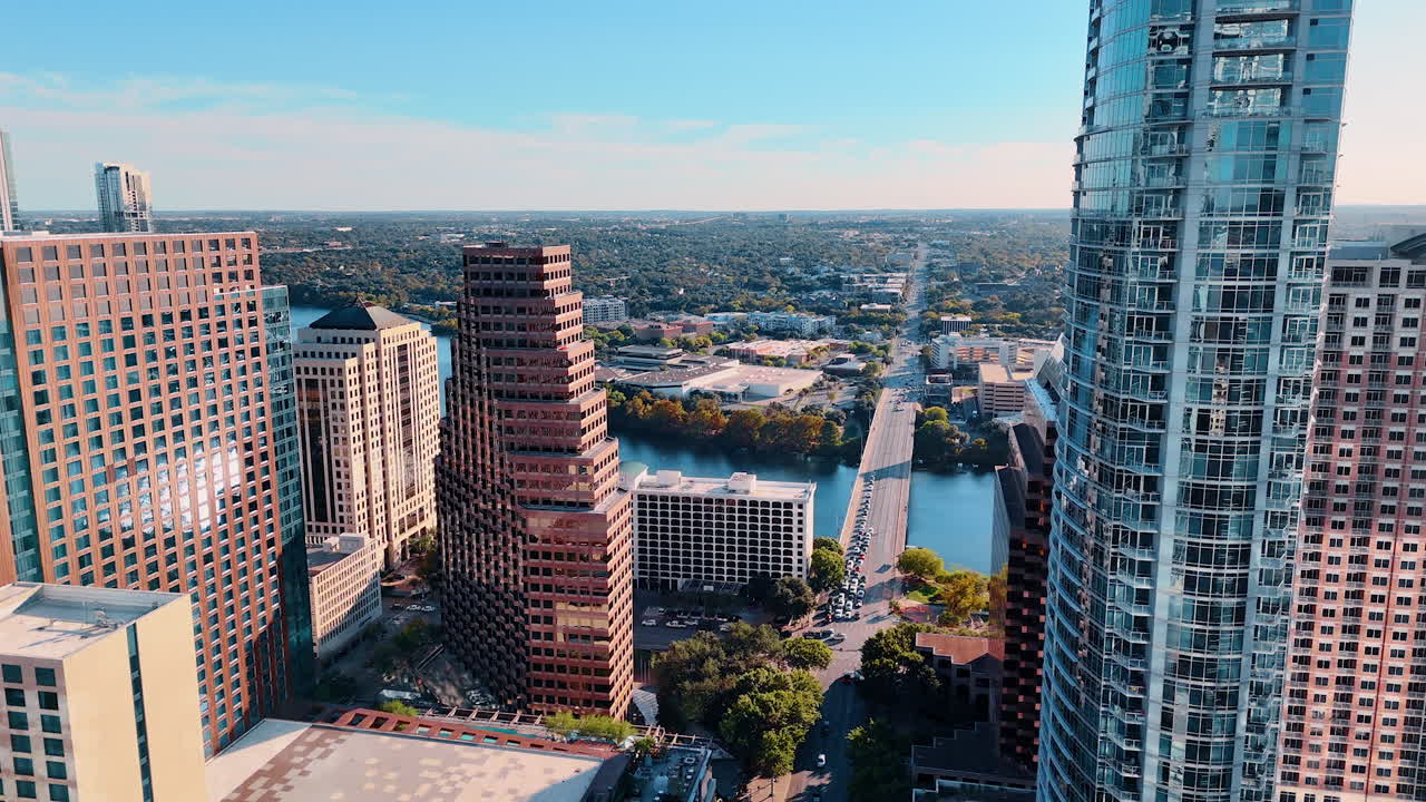 Austin, USA, 21 novembre 2025: vista prospettica del ponte di Congress Avenue e del fiume Colorado. Ripresa da drone che guarda lungo il fiume verso un ponte con edifici urbani e un orizzonte verde.