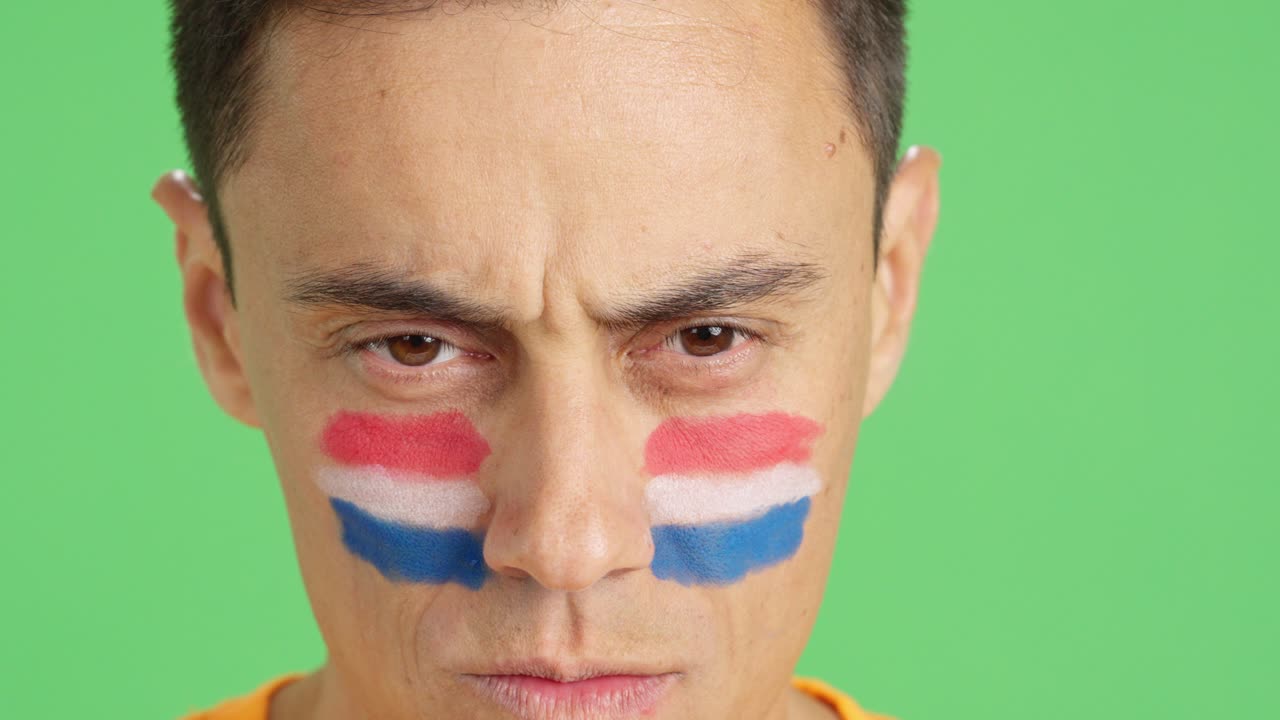 Serious man with a dutch flag painted on the face