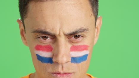 serious man with a dutch flag painted on the face