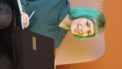 video vertical de una mujer joven haciendo una videollamada en una computadora portátil.