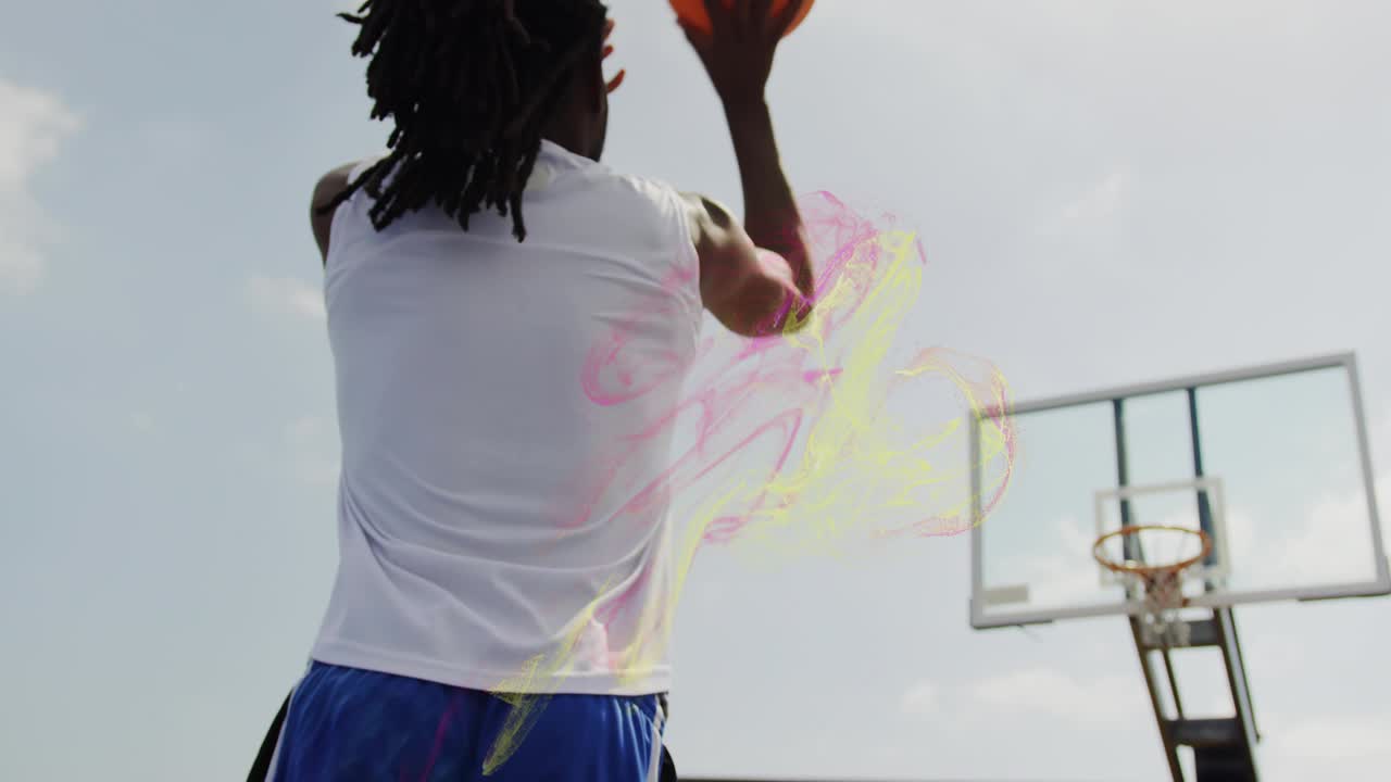 Male athlete shooting basketball on outdoor court with pink trails and grabbing ball for training