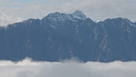 cloud inversion below the remarkables mountain range in queenstown, nz