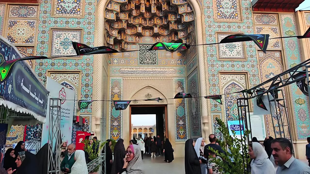 Persone che visitano l'ingresso decorato di un edificio islamico tradizionale