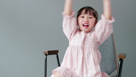 Cheerful-and-happy-child-looking-at-camera-and-swing-arms-and-pointing-to-something