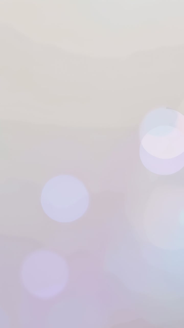 Vertical video: Shifting pale bokeh in studio as frames advance, showing blue flares as decor