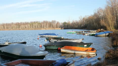 Kleine-Bunte-Fischerboote,-Die-Nahe-Am-Ufer-Eines-Sees-Schwimmen