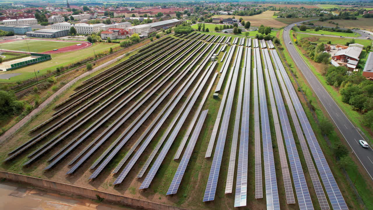 An Aerial orbit shot of rows of solar photovoltaic panels for sustainable electric power for city and industries in a German