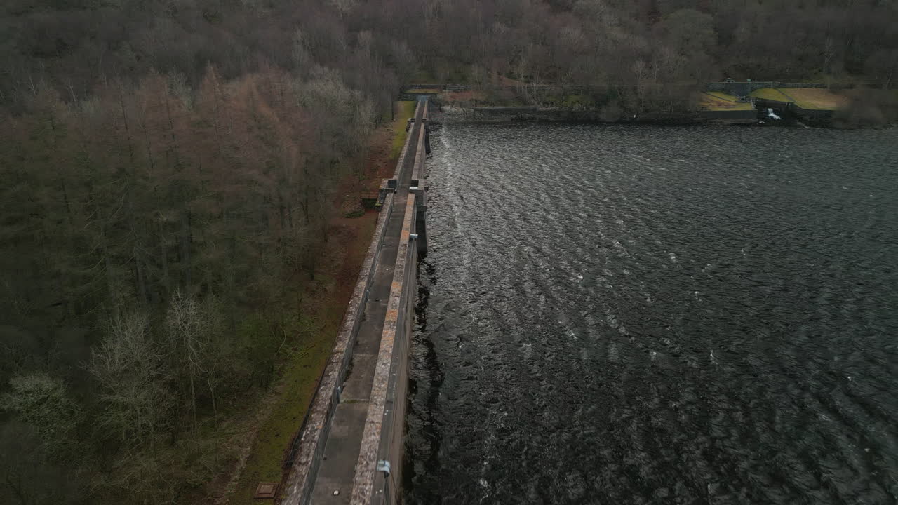 Flying along reservoir dam wall at Haweswater English Lake District UK