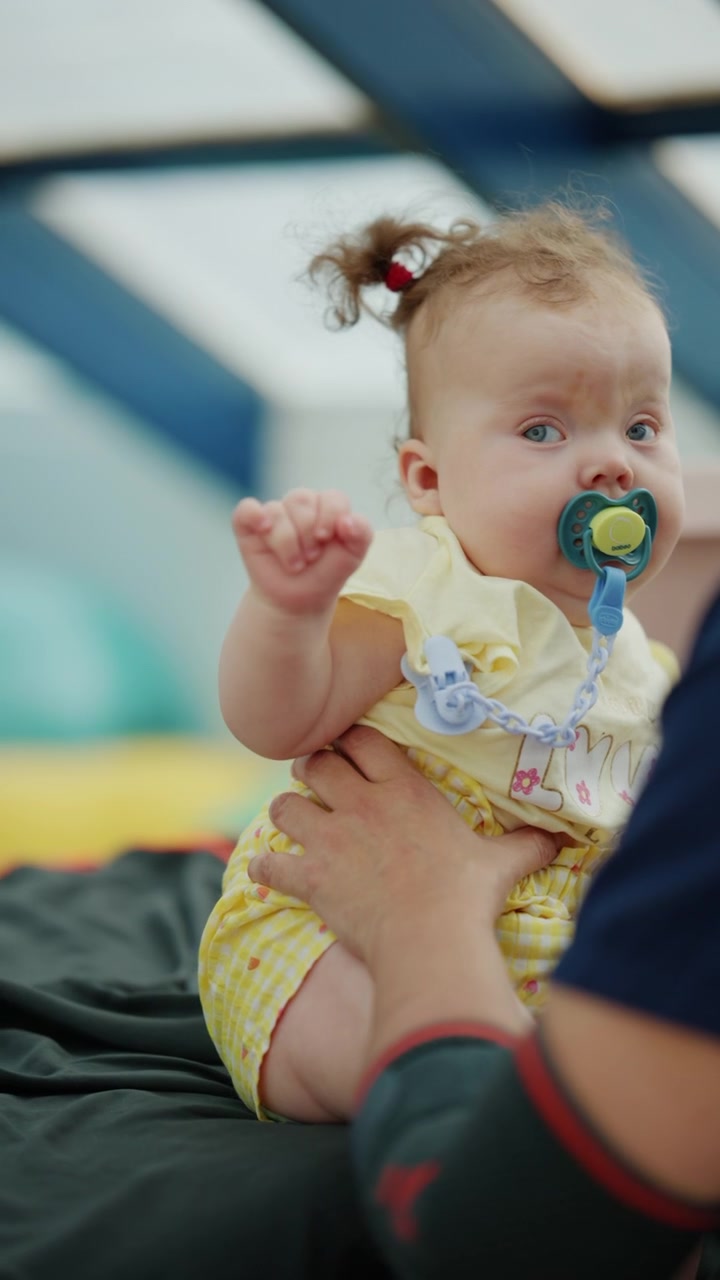 Cute baby with curly hair and pacifier finding comfort, representing childhood, innocence, and care