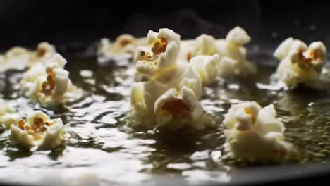 watch as fluffy popcorn kernels burst to life in hot oil, creating a delicious snack. experience the satisfying transformation and inviting aroma filling the kitchen during this cooking moment.