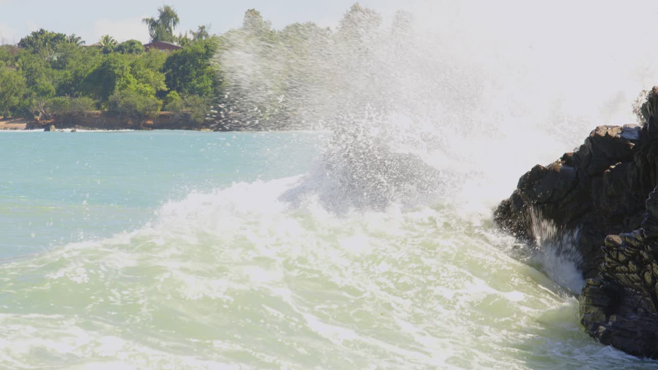 океанские волны промывают и брызгают по скалистому побережью гваделупы.