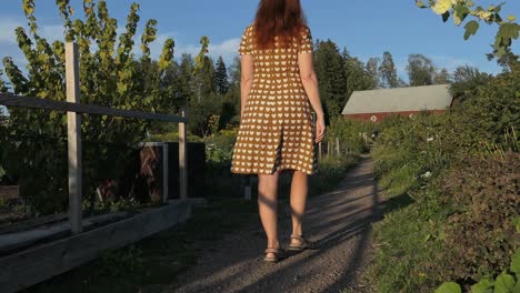 mujer en el jardín caminando a la casa de campo en el campo