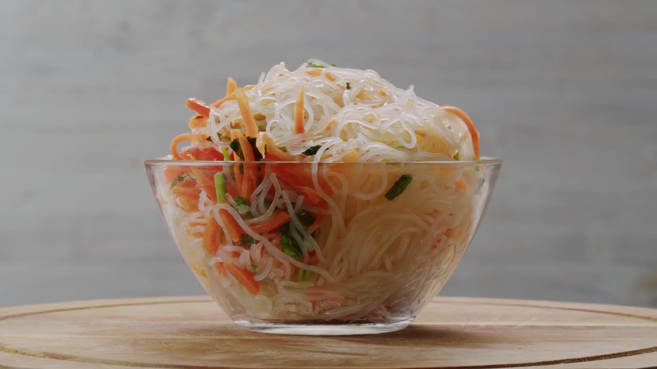 Glass noodles salad with meat and carrots fermented close up asian chinese traditional food.
