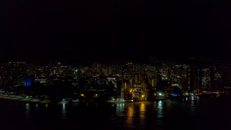 distant aerial view of honolulu hawaiii and waikiki at night