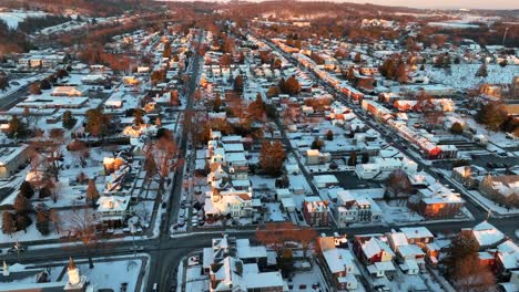 amplia revelación aérea de una ciudad americana nevada durante la hora dorada del atardecer de invierno