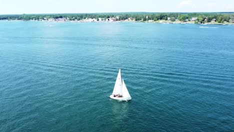 aerial orbit of sailboat in summer sun - hessel, michigan - lake huron