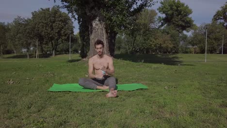 Young-athletic-man-with-mask-performing-yoga-pose-in-park,-zen-wellness-woman-performs-yoga