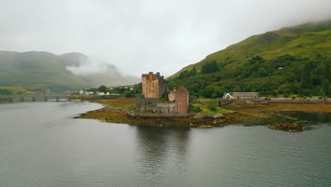 Amplia-Panorámica-Aérea-Del-Histórico-Castillo-De-Eilean-Donan-En-Loch-Duich,-Tierras-Altas-Escocesas-En-Otoño-En-Un-Día-Nublado,-Escocia,-Reino-Unido