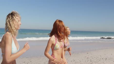 young adult female friends running at the beach 4k