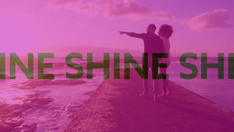 animation of shine text over couple walking on beach into sea with pink tint