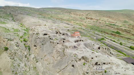 iglesia basílica en la ciudad cueva de uplistsikhe rodeado por drone revelando, kura