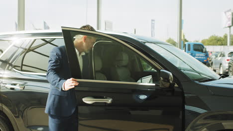 hombre abriendo la puerta del coche en el concesionario
