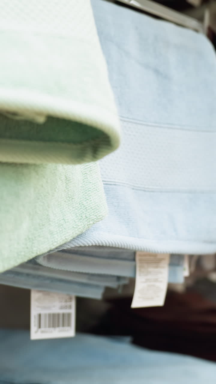 view of neatly arranged hand towels in various colors on store shelves., this video showcases the organized display of towels in a retail environment, highlighting their sizes and eco-friendly labels