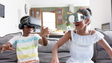 Glücklicher-Afroamerikanischer-Bruder-Und-Schwester-Mit-VR-Headsets-Auf-Dem-Sofa,-Zeitlupe