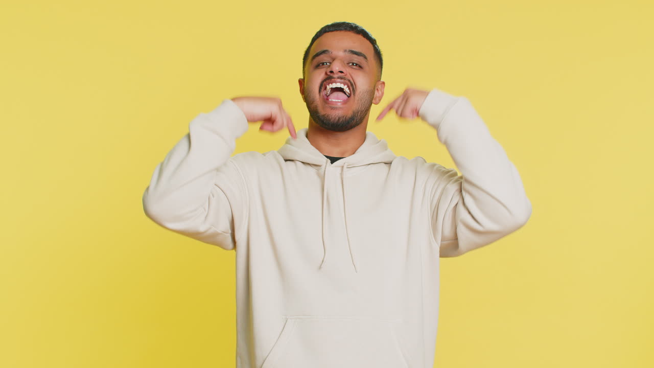 Excited indian young winner man feeling very proud pointing hisself overjoyed by success victory