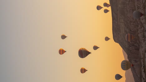 vertical 4k timelapse, hot air balloons flying above cappadocia at sunrise