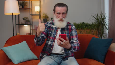 abuelo mayor en casa usar teléfono inteligente escribir navegación, wow sí descubrió gran gran victoria celebrar
