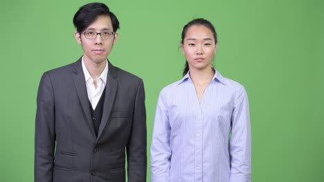 young asian business couple nodding head no together