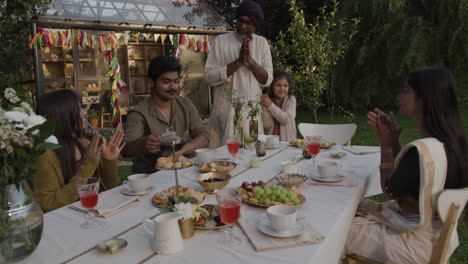 multigenerational family enjoying a festive outdoor meal and tea party