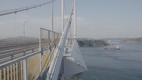 le pont suspendu de kurushima kaikyo alors qu'un cargo parcourt la mer intérieure de seto