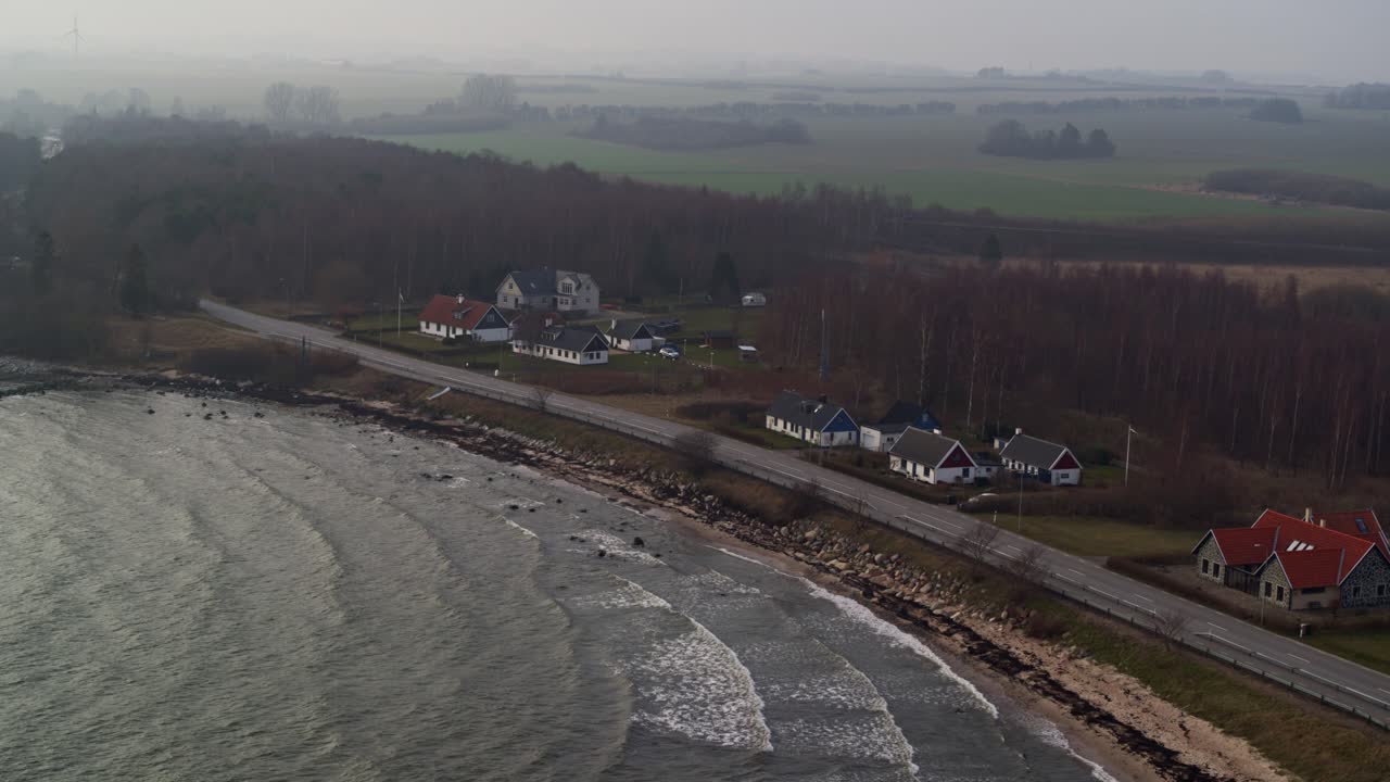 거리가 있는 해변과 숲 가장자리에 있는 가족 주택의 공중 전망